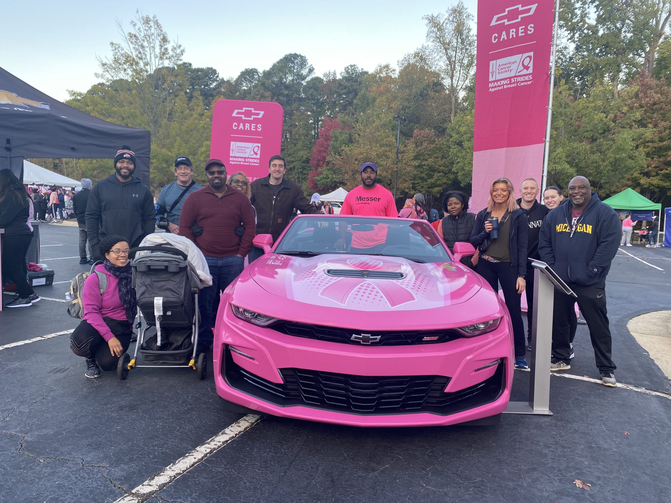 Messer Construction Company employees posing in front of a pink car at a Breast Cancer Walk