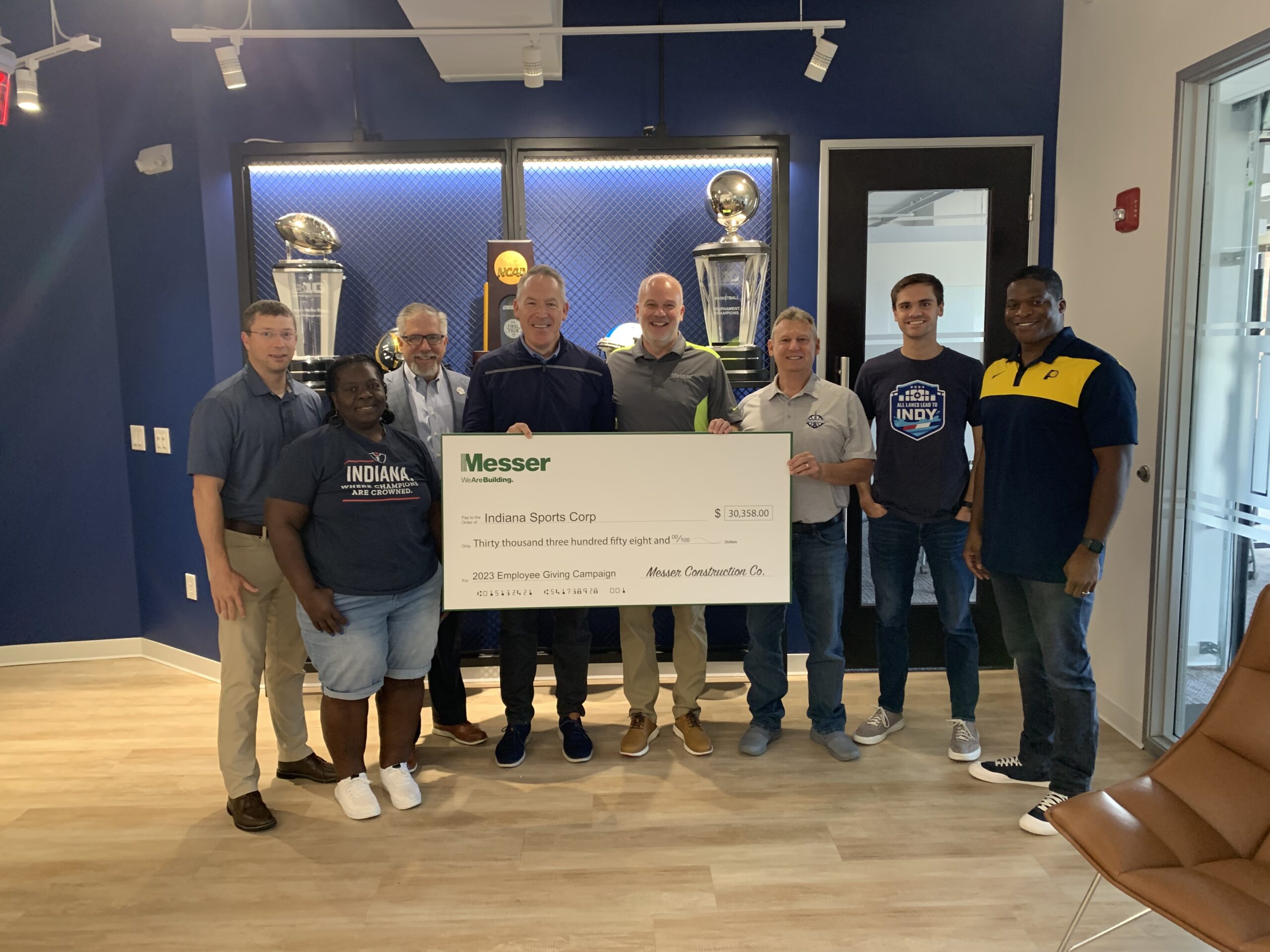 Messer Construction Company employees presenting check to Indiana Sports Corp