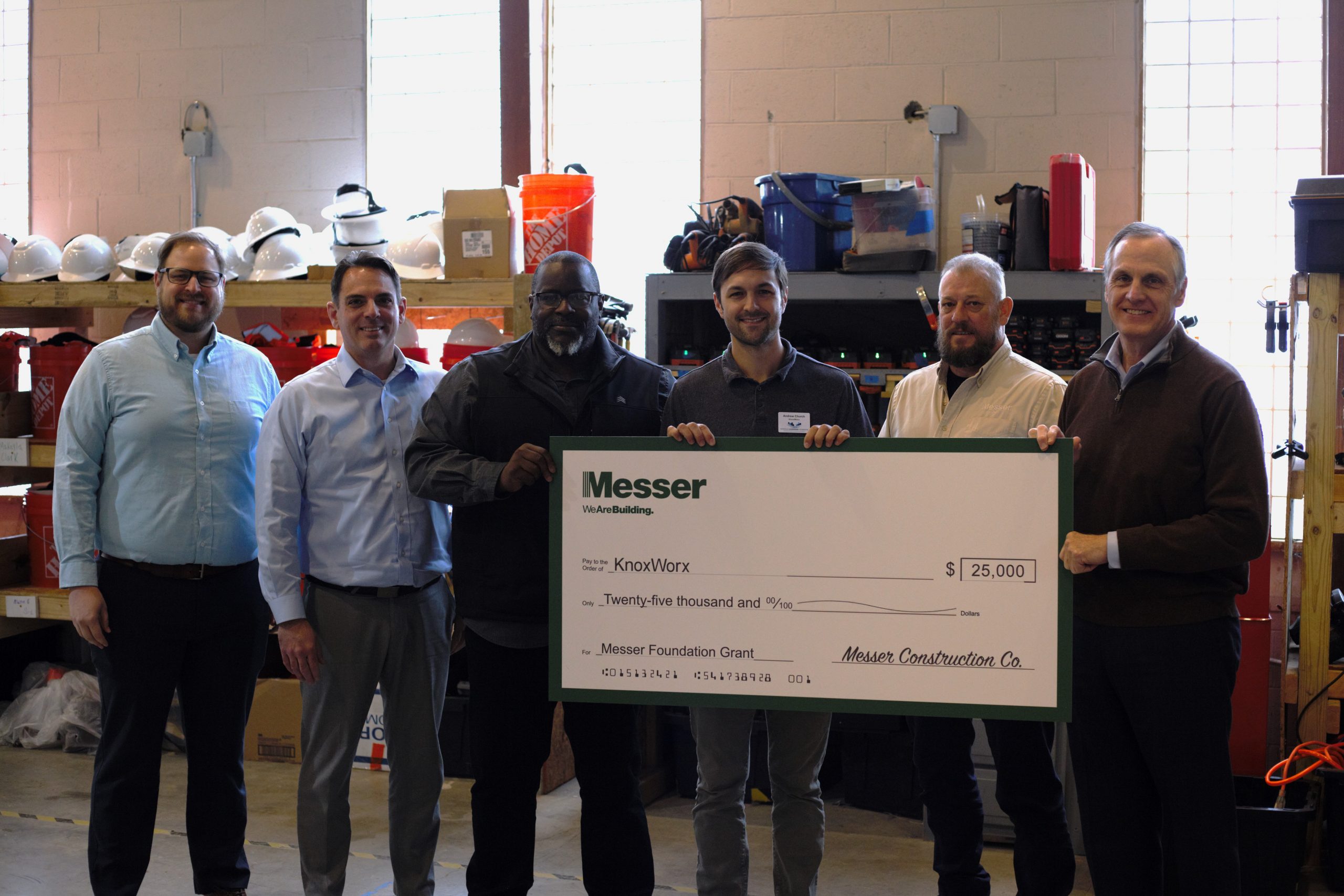 Messer Construction Company employees posing for the camera holding a large check
