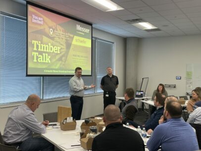 Two people presenting in a room full of people