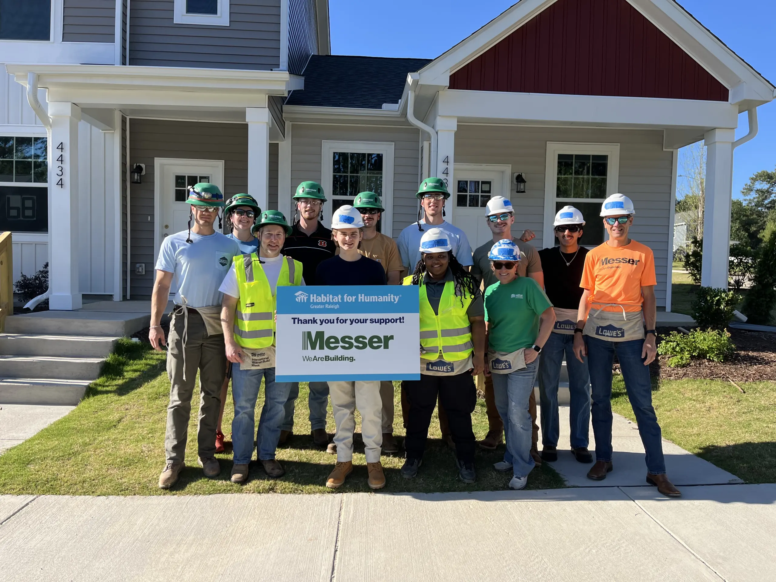 Messer Construction Co. Raleigh NC Habitat for Humanity Volunteer event - group photo outdoors in front of sponsor sign