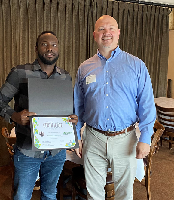 Careers in construction at Messer. Messer apprenticeship graduate holding certificate